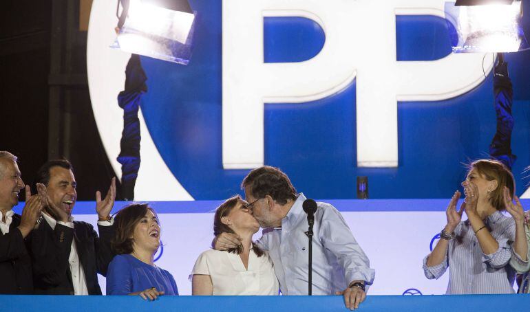 Fotografía facilitada por el PP de su líder y presidente del Gobierno en funciones, Mariano Rajoy (2d), que besa a su mujer, Elvira Fernández, ante la secretaria general del partido, María Dolores de Cospedal (d); la vicepresidenta del Gobierno en funcion