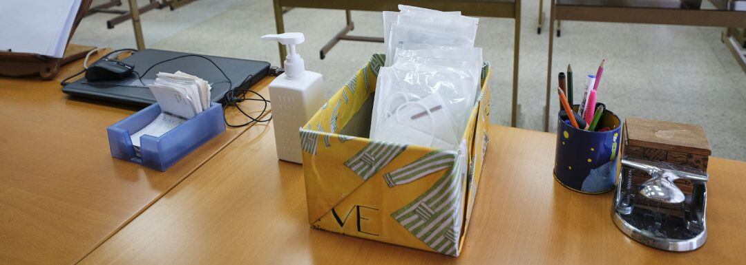 Archivo - Mascarillas y gel desinfectante en la mesa del profesor de un aula en una imagen de archivo