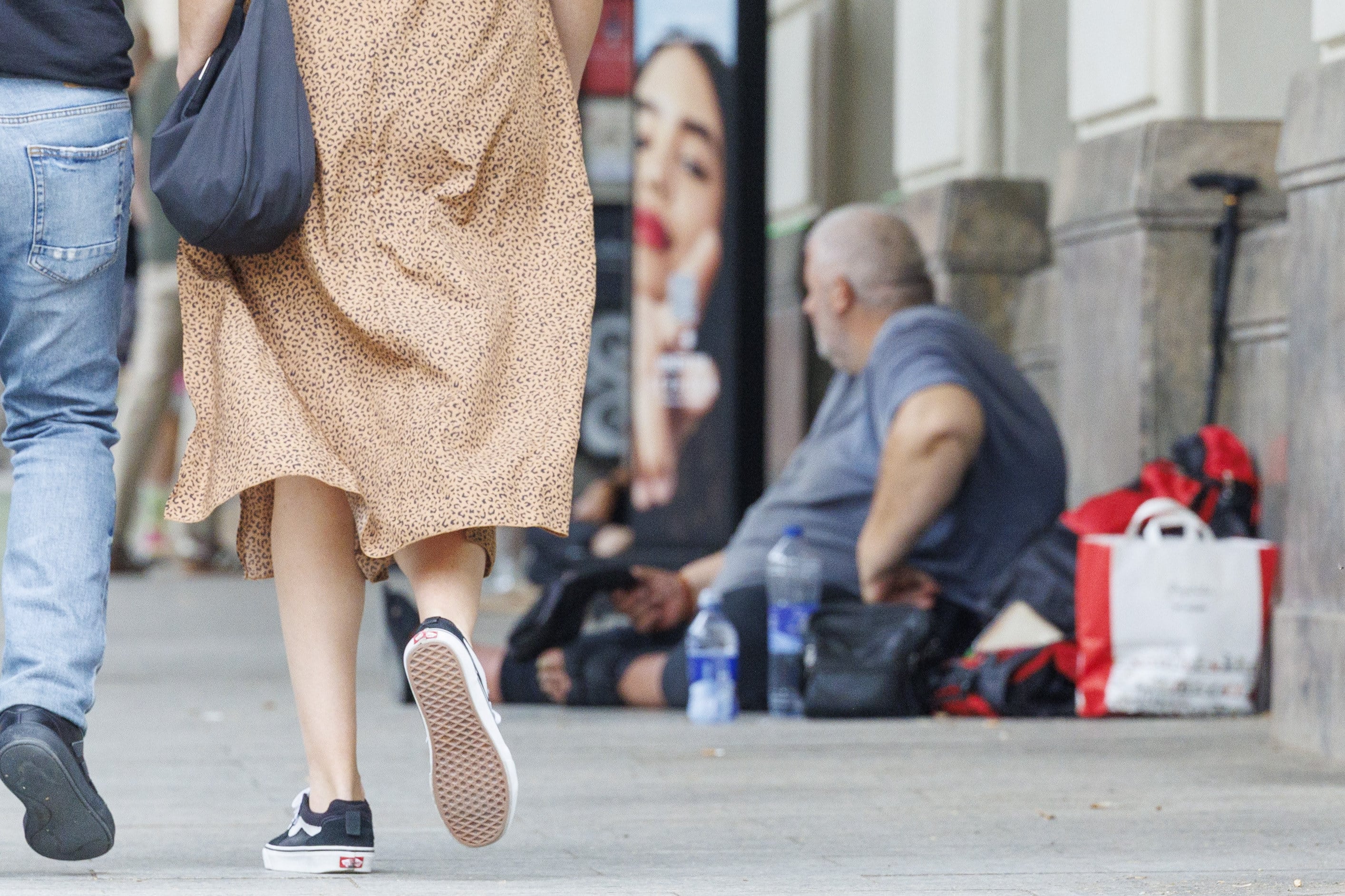 ZARAGOZA, 13/06/2025.- Un hombre pide limosna en una céntrica avenida de Zaragoza. Lejos del estereotipo de cartón en la acera, el sinhogarismo se ha vuelto más invisible y complejo, con trasteros alquilados por hasta 60 euros en Zaragoza, habitaciones compartidas o viviendas okupadas sin agua ni luz. EFE/Javier Cebollada
