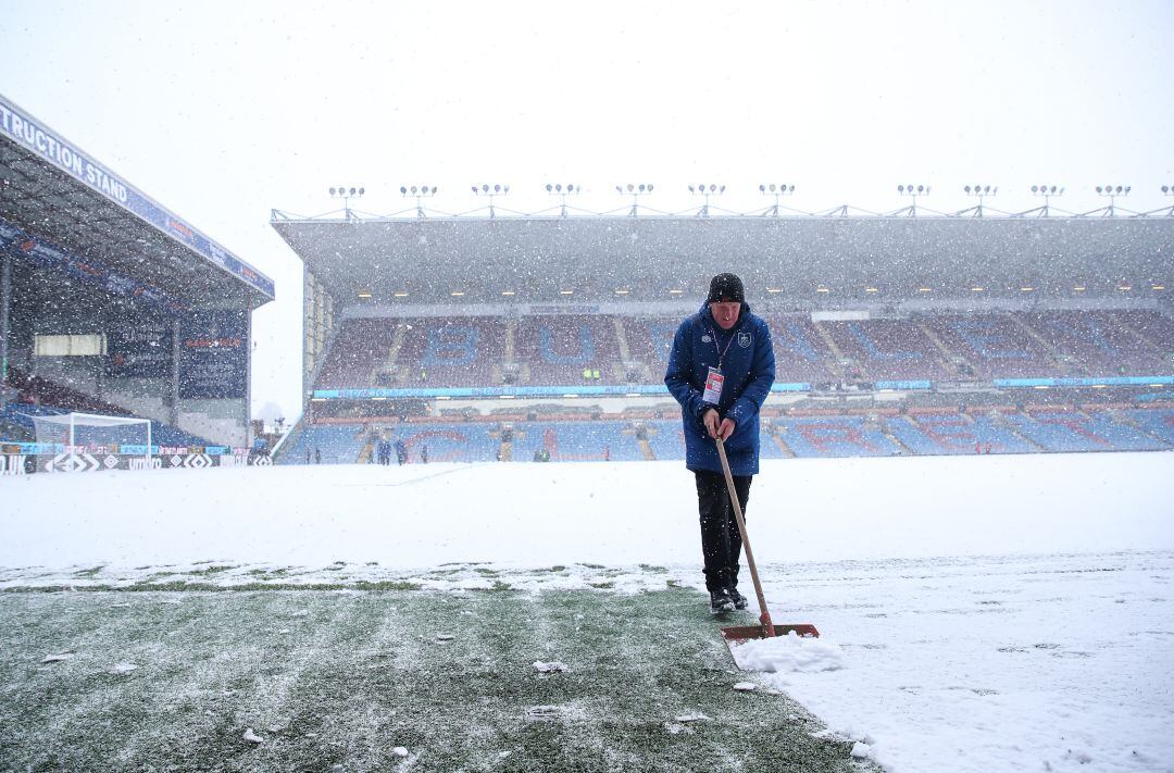 Un operario del Burnley quitando nieve sobre Turf Moor