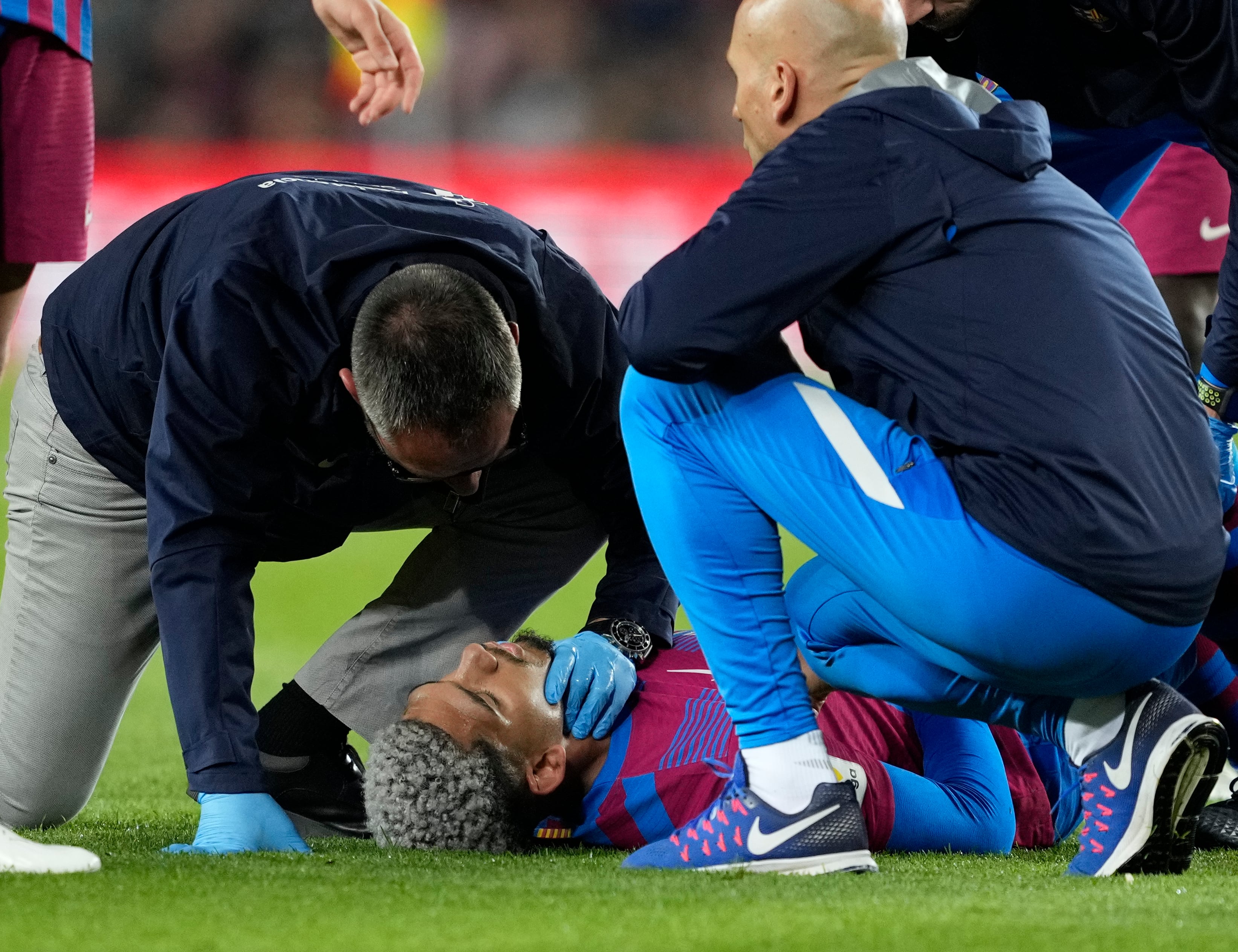 El defensa uruguayo del FC Barcelona, Ronald Araujo, asistido tras sufrir un golpe durante el encuentro frente al Celta