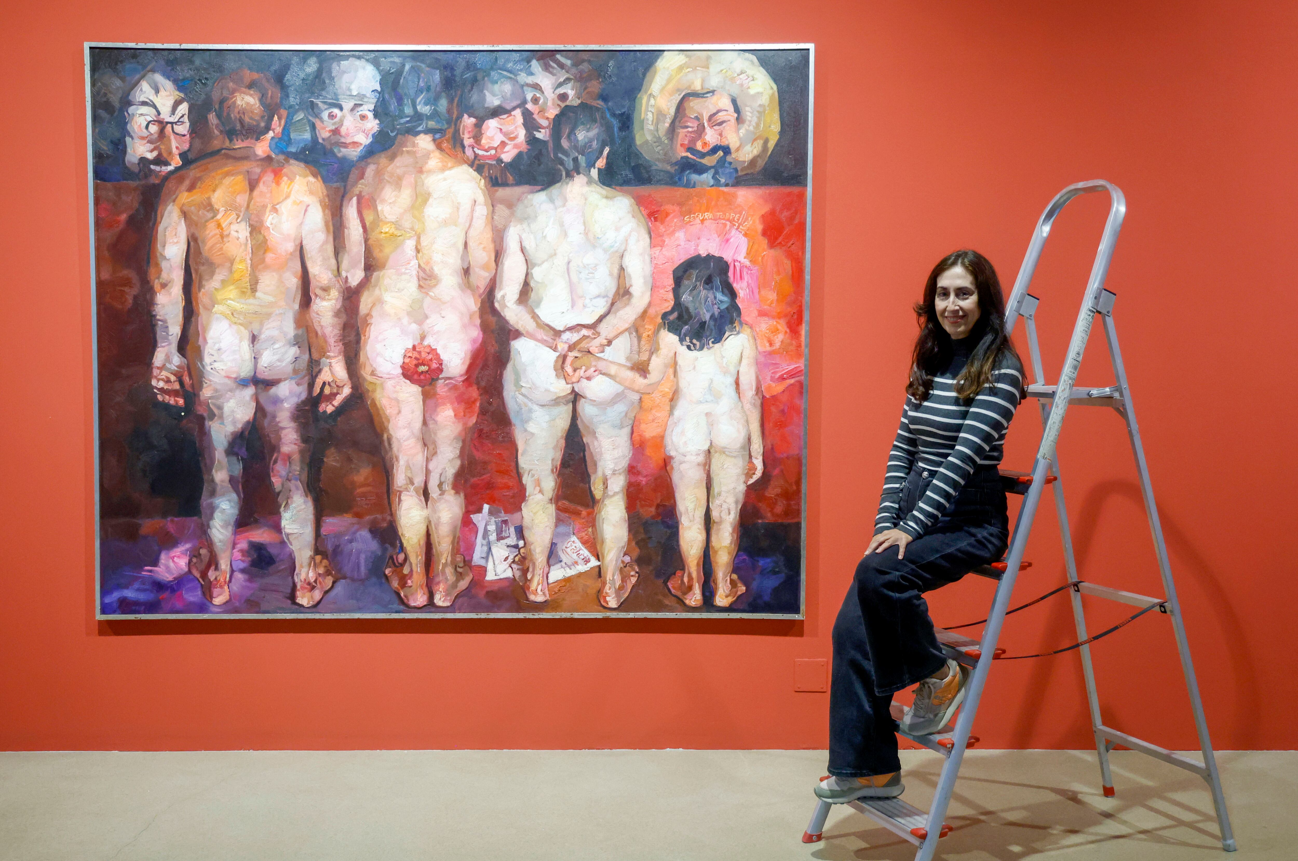 Helena, hija del pintor ferrolés Ricardo Segura Torrella, posa ante obras de su padre que forman parte de la retrospectiva (foto: Kiko Delgado / EFE)