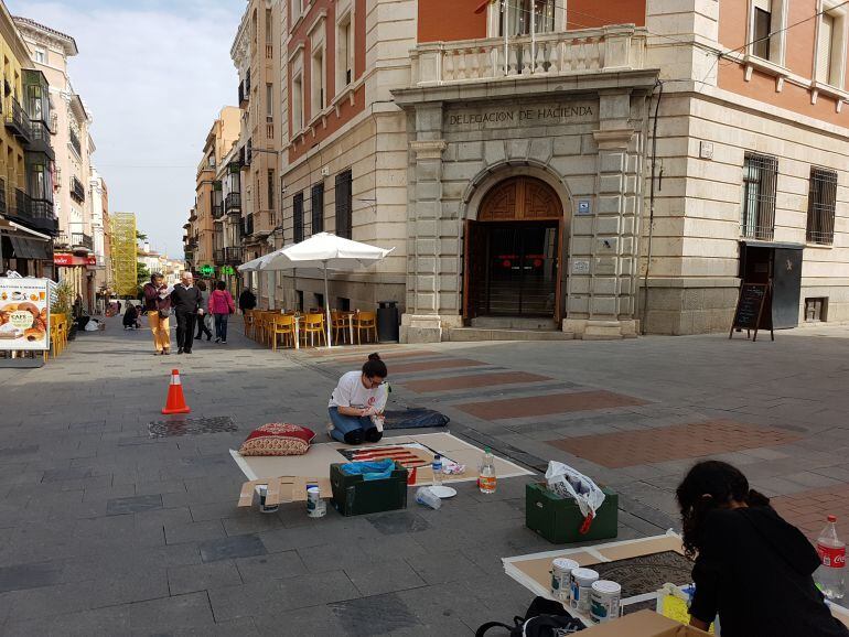Alumnos pintando alcantarillas en la Calle Mayor
