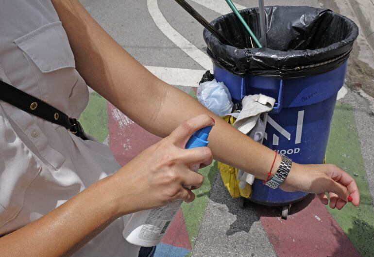 Una mujer utiliza repelente de mosquitos para evitar el virus zika