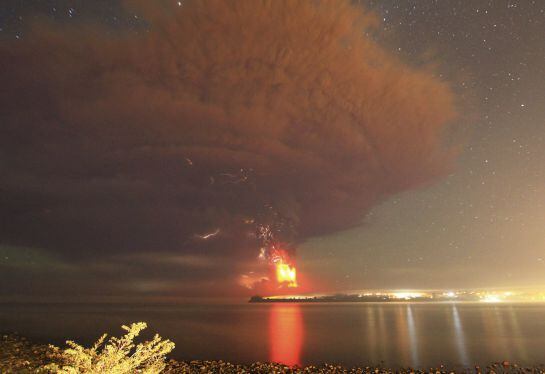 Smoke and lava spew from the Calbuco volcano, as seen from the shores of Lake Llanquihue in Puerto Varas, April 23, 2015. The Calbuco volcano in southern Chile erupted for the first time in more than five decades on Wednesday, sending a thick plume of ash