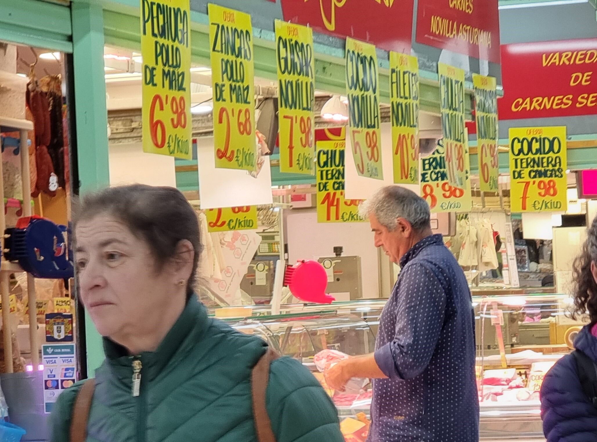 Clientes ante una pescadería de Mercado El Fontán