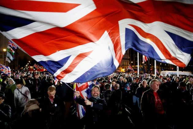 Un hombre despliega una bandera británica &quot;gigante&quot; durante la celebración en las calles de Londres.