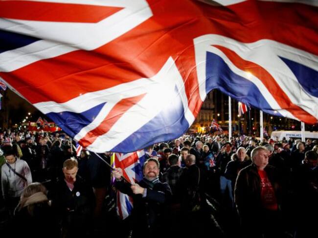 Un hombre despliega una bandera británica "gigante" durante la celebración en las calles de Londres.