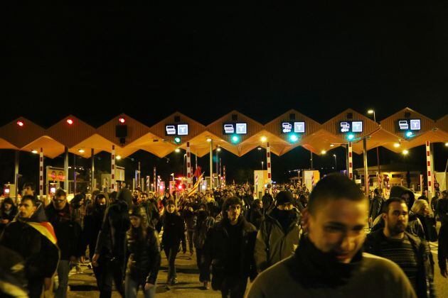 Pla obert de l'entrada de centenars de manifestants al peatge de l'AP-7 a Tarragona. Imatge del 25 de març de 2018.