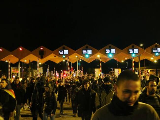Pla obert de l'entrada de centenars de manifestants al peatge de l'AP-7 a Tarragona. Imatge del 25 de març de 2018.