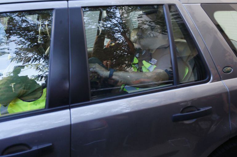 Oleguer Pujol (C), son of former president of Catalonia Jordi Pujol, covers his face as he is driven away by police after he was detained as part of an investigation by a High Court examining judge for tax fraud and money laundering in Barcelona October 2