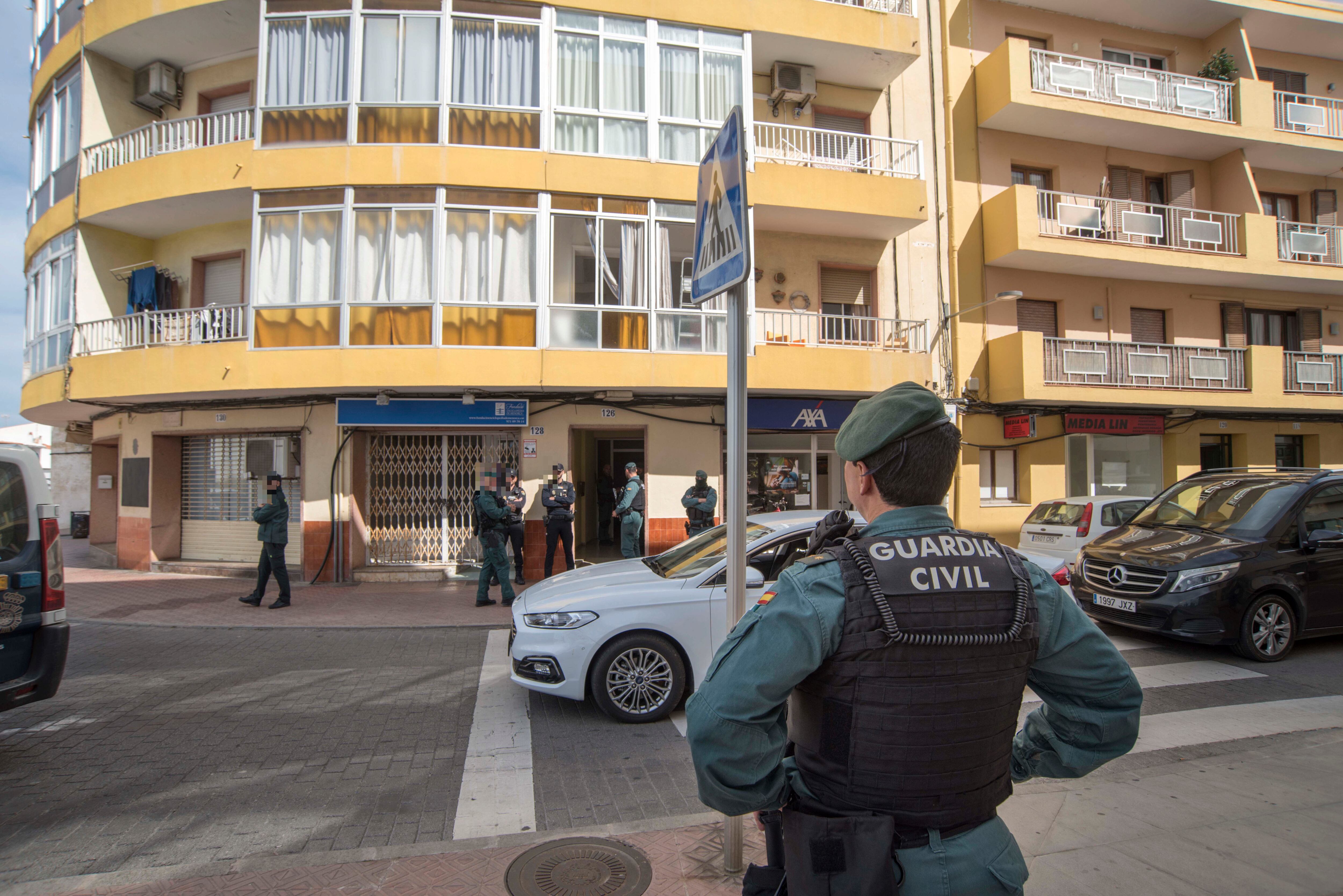 MAHÓN (MENORCA), 24/03/2023.- Efectivos de la Policía Nacional y de la Guardia Civil permanecen apostados este viernes en la calle de Sant Manuel de Mahón, donde llevan a cabo desde primera hora de la madrugada de este viernes una amplia operación contra el tráfico de drogas en Mahón, han confirmado fuentes policiales. EFE/ David Arquimbau Sintes