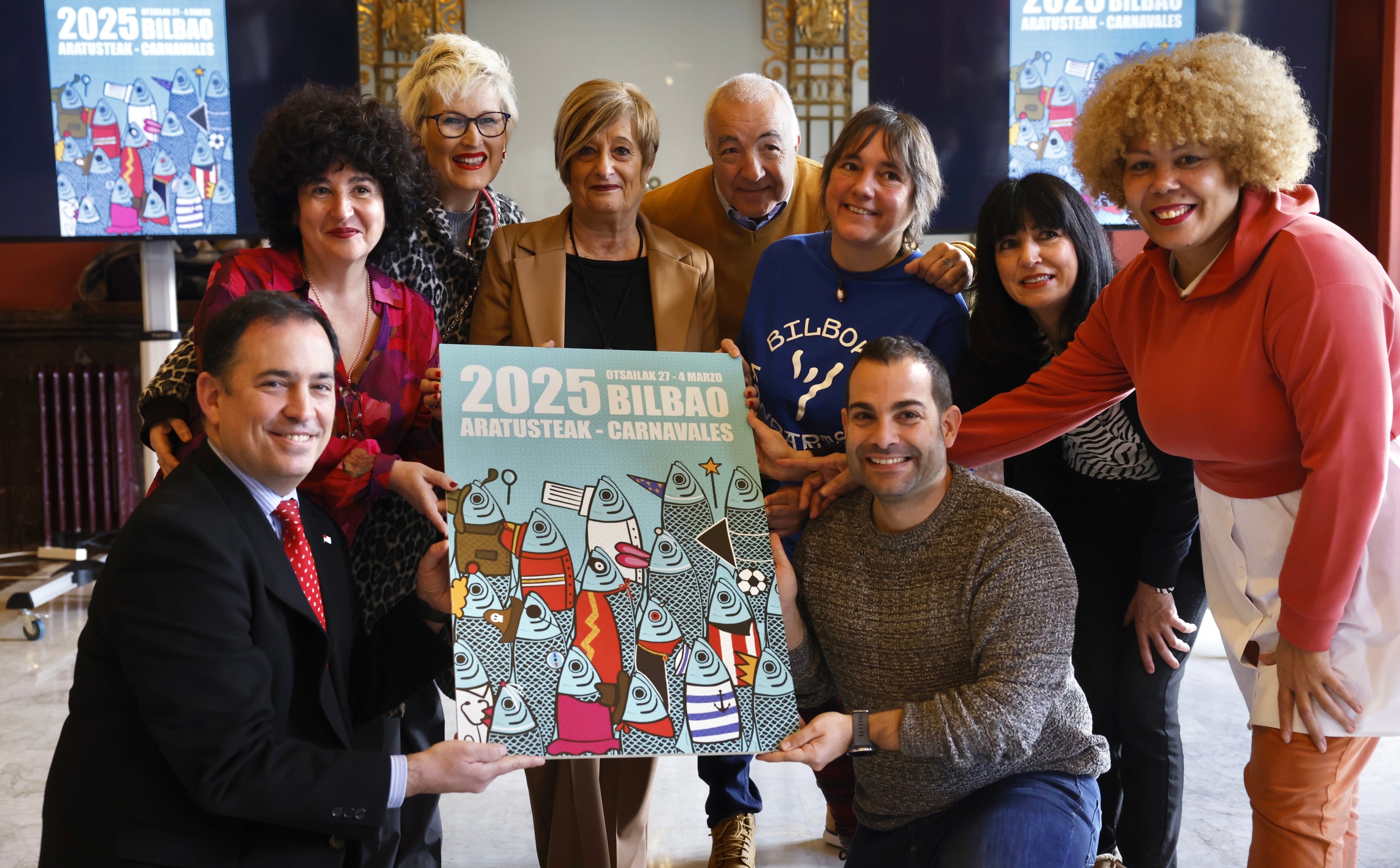 &#039;Todos somos sardinas&#039; cartel ganador de los carnavales de Bilbao 2025. En la foto, los portavoces municipales, Bilboko Kompartsak y la ganadora Elena Echeverría