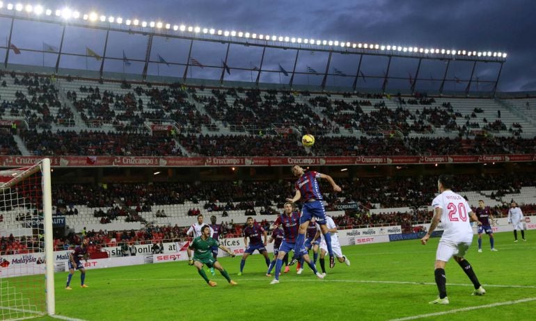 Eibar's Mikel Arruabarrena (C) jumps to head the ball over Sevilla's Alejandro Arribas during their Spanish First Division soccer match at Ramon Sanchez Pizjuan stadium in Seville, December 14, 2014. REUTERS/Marcelo del Pozo (SPAIN - Tags: SPORT SOCCER)