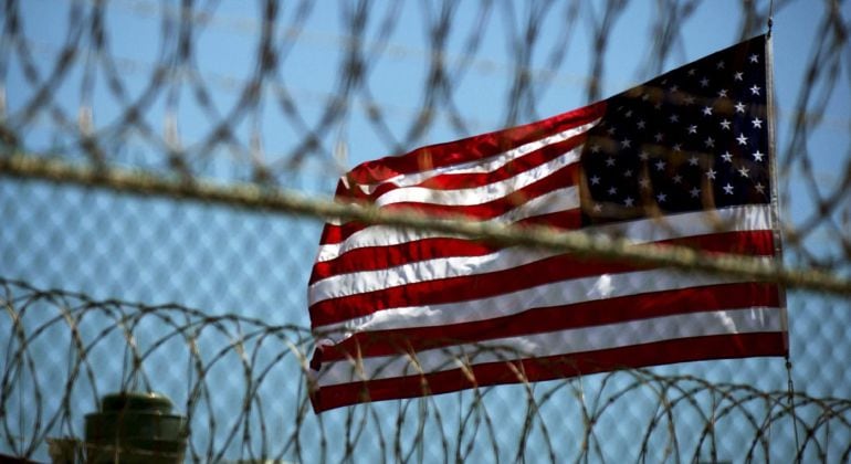 La bandera estadounidense ondea tras los alambres de seguridad en una estación naval en Guantánamo.