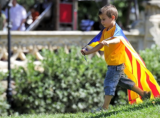 Un niño pasea con la bandera catalana en la celebración de la Diada / AFP