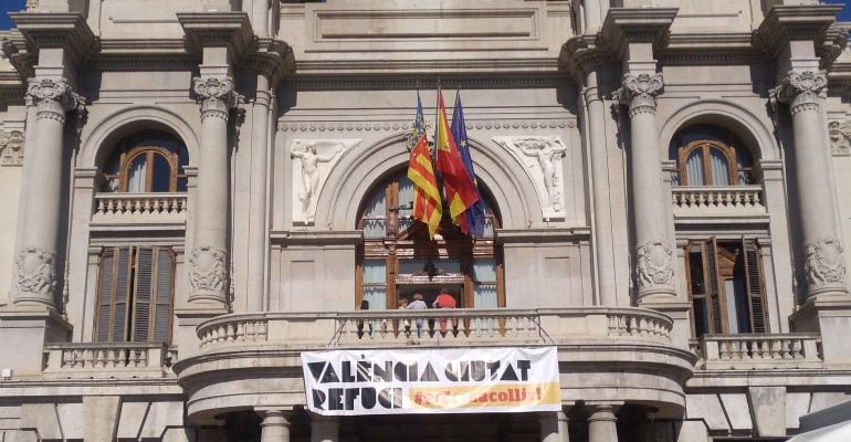 En la fachada del Ayuntamiento de Valencia ya luce una pancarta dando la bienvenida a los migrantes que viajan en el Aquarius