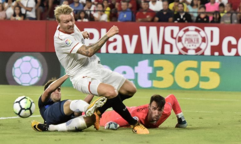  Los jugadores del Sevilla FC, el defensa danés Simon Kjær (c) y el portero Sergio Rico (d), luchan el balón con el brasileño Leo Baptistao.