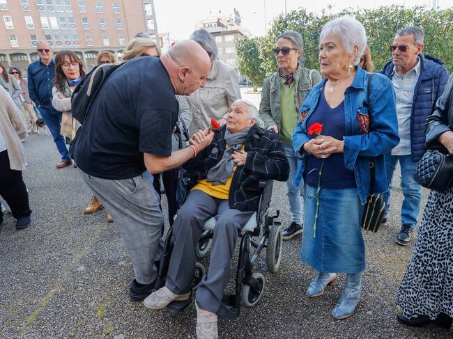 FERROL, 08/04/2023.-Quico Permuy da una flor a una de las tías mayores del cámara Ferrolano, durante la concentración y ofrenda floral en el homenaje al cámara de Telecinco José Couso este sábado, muerto en la guerra de Irak hace 20 años, y en la que amigos, familiares y representación política han puesto flores en la plaza de la Paz de Ferrol.-EFE/Kiko Delgado