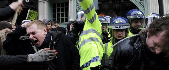 Policias hacen frente a los manifestantes durante la protesta en Londres