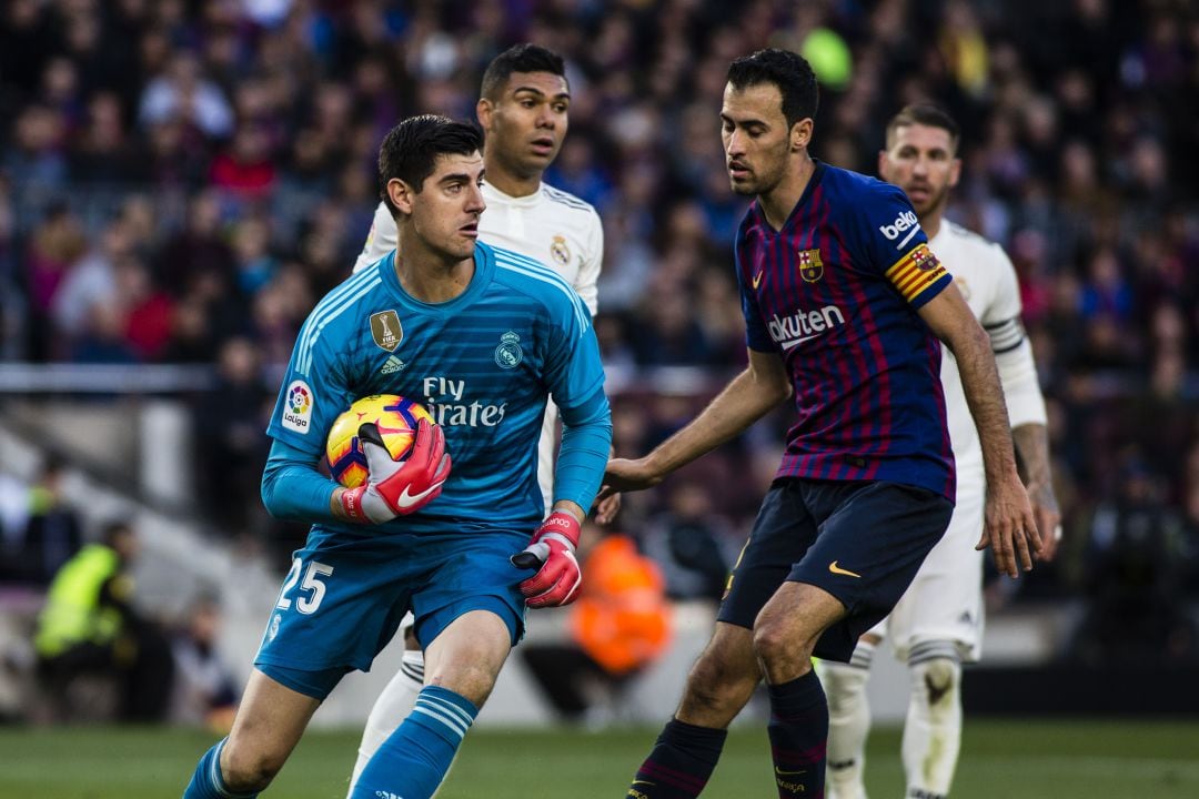 Courtois y Busquets, durante un Clásico entre Barcelona y Real Madrid.