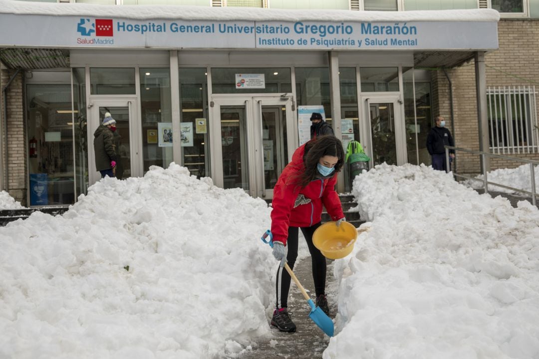 Un grupo de vecinos trabaja para despejar los accesos al Hospital Gregorio Marañón de Madrid, este domingo.