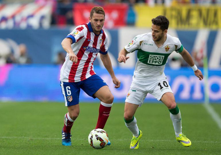 Koke pelea un balón junto a Corominas durante el enfrentamiento ante el Elche