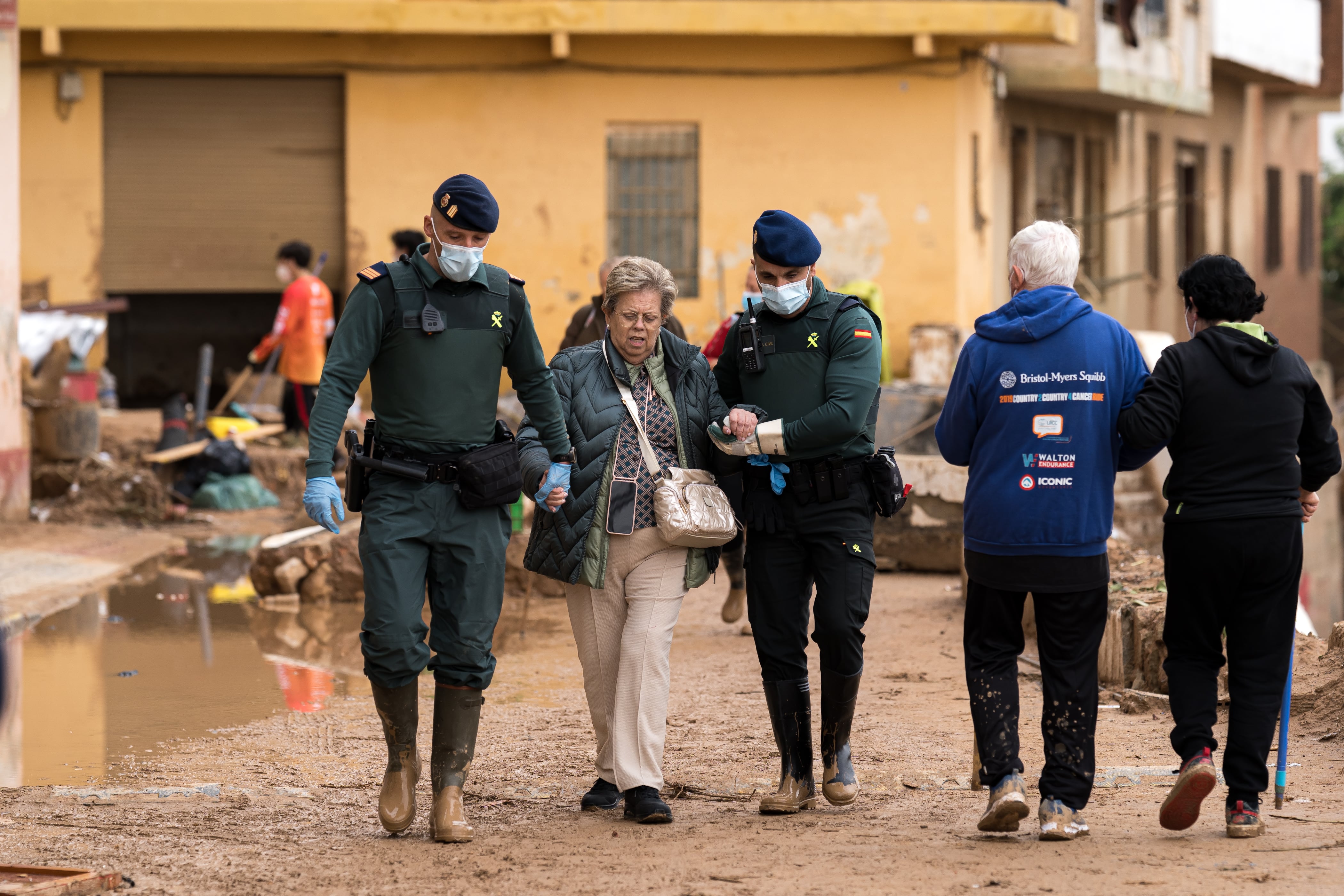 Dos agentes de la Guardia Civil ayudan a una mujer.