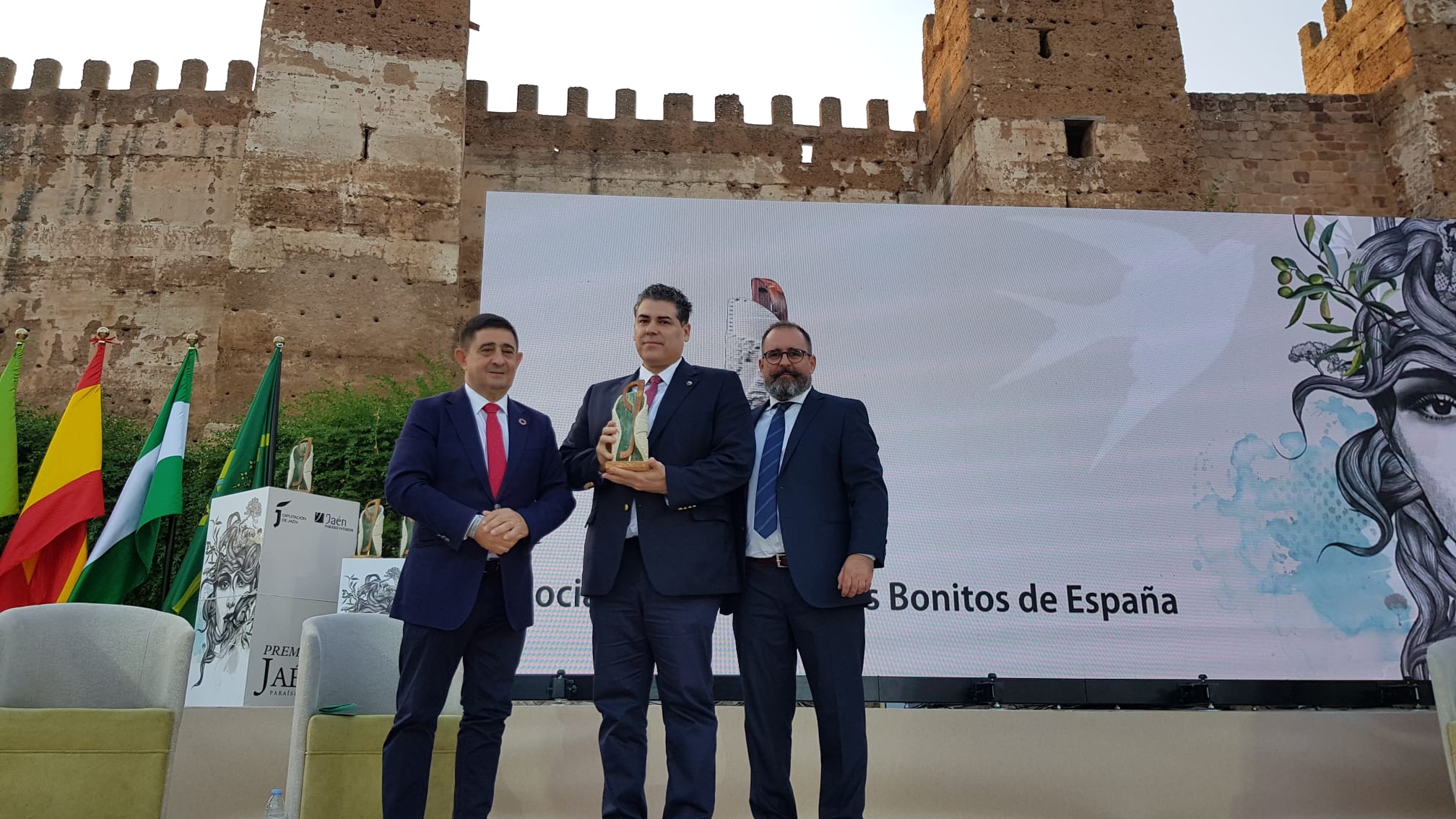 El presidente de la Asociación de Pueblos más Bonitos de España, Francisco Mestre, recoge el premio de manos del presidente de la Diputación y el alcalde de Baños de la Encina