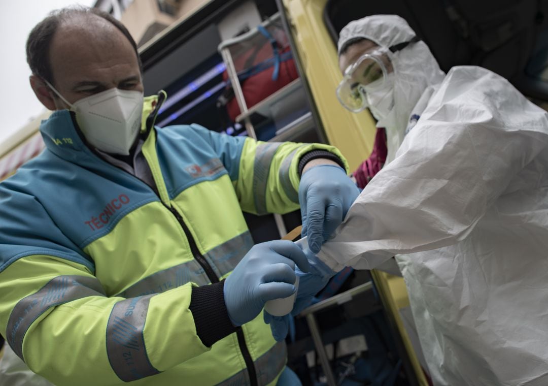 Un trabajador de la UCI móvil del SUMMA 112 es ayudado por un compañero para colocarse la EPI durante un día de trabajo el pasado mes de enero en Madrid. 