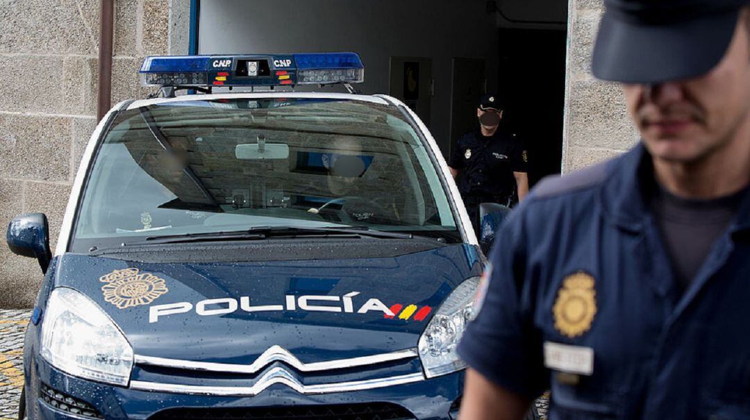 Imagen de archivo de un vehículo policial y varios agentes de la Policía Nacional