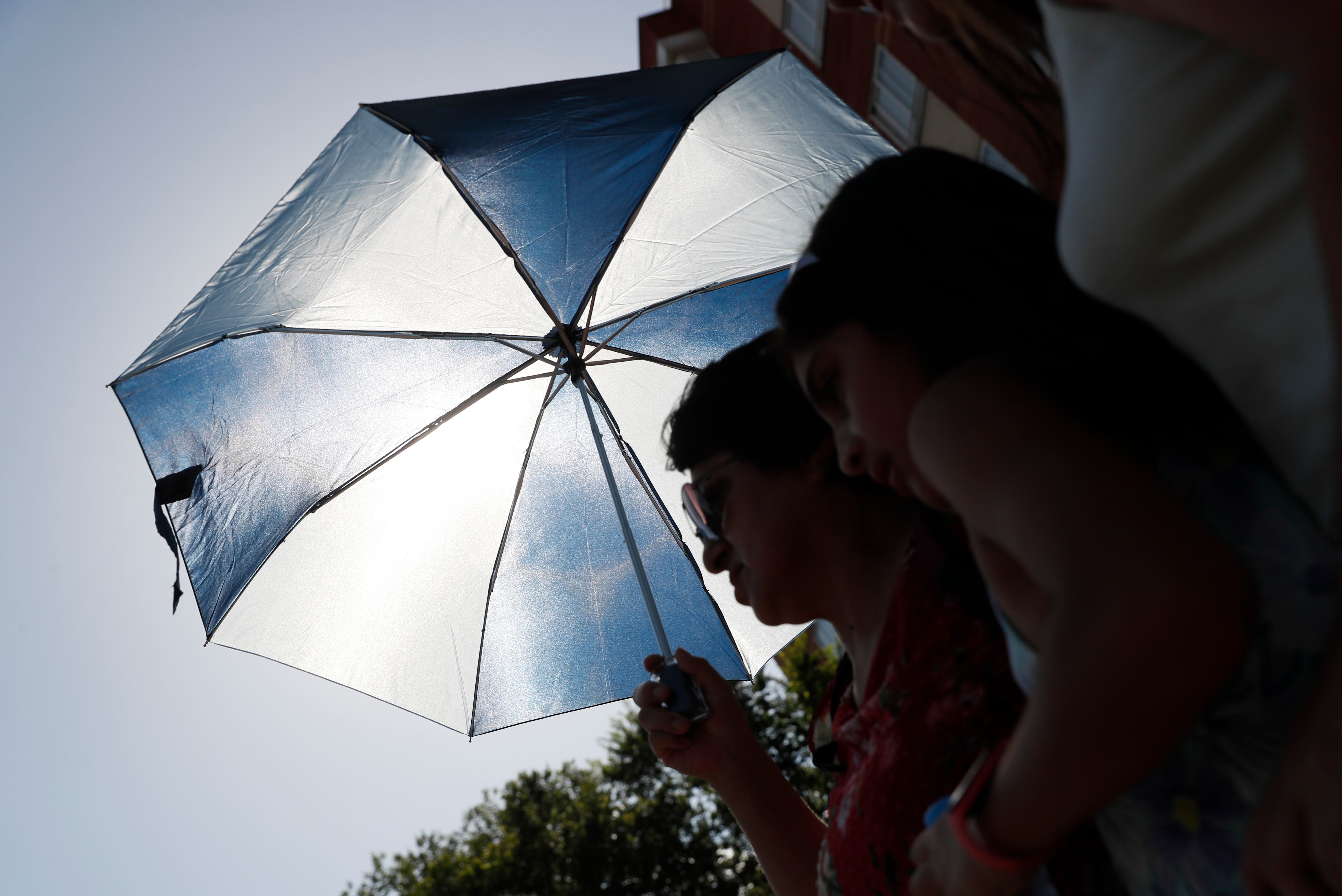 Una mujer y su hija se cubren del sol con un paraguas debido a la ola de calor en España. EFE/ Mariscal