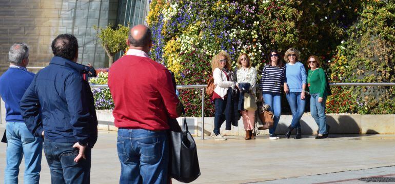 Un grupo de turistas haciéndose una foto junto Puppy en el Guggenheim