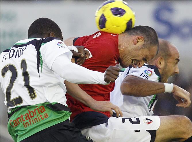 El centrocampista de Osasuna Fernando Soriano (c) disputa un balón por alto ante los centrocampistas del Racing dse Santander Gonzalo Colsa (d) y el senegalés Papakouly "Pape" Diop