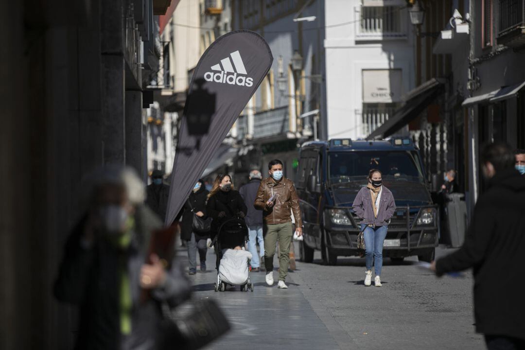 Personas caminando por una centrica calle de Sevilla durante el primer día de cierre perimetral