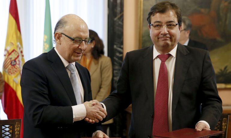 Cristóbal Montoro y  Guillermo Fernández Vara se saludan tras la firma del protocolo