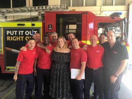 Adele posando con los bomberos en la estación.