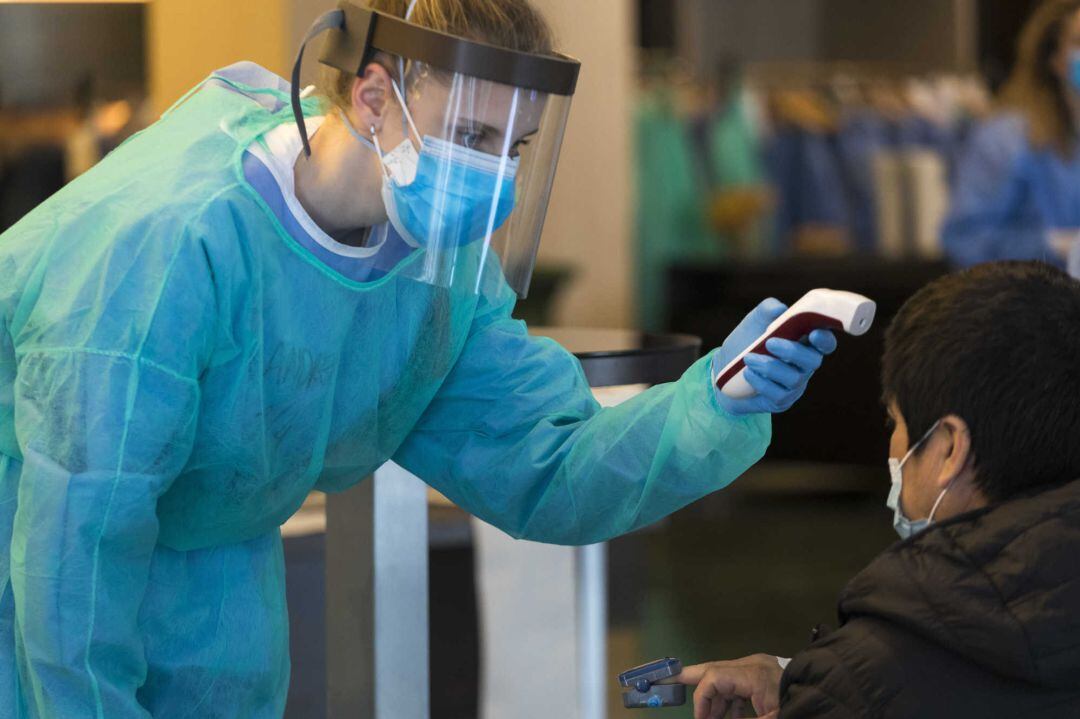 Sanitaria tomando la temperatura a una paciente