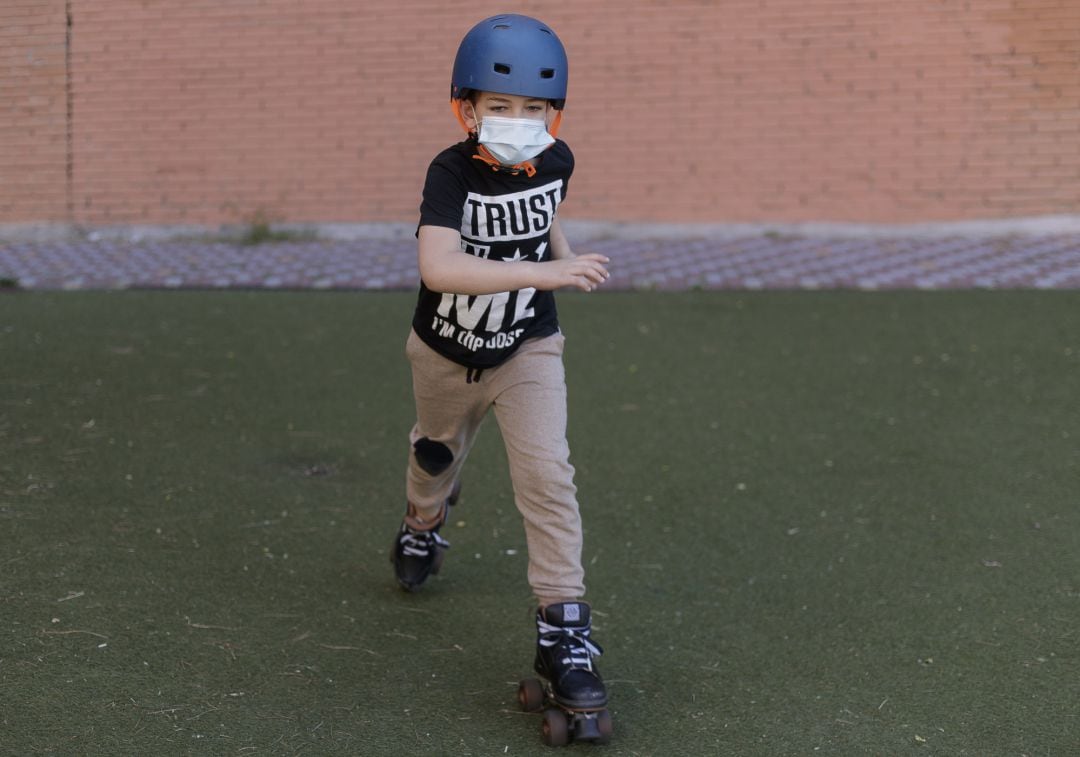 Un niño patina por la calle protegido con una mascarilla tras el anuncio realizado por el Gobierno, quien ha fijado que la utilización de cualquier tipo de mascarillas será obligatorio a partir de este jueves