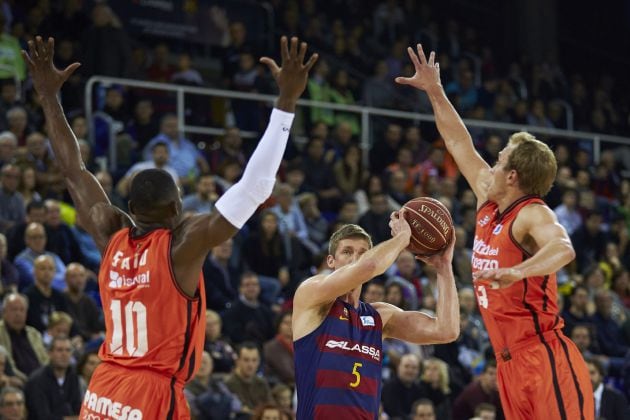 El ala pívot norteamericano del Barcelona Lassa Justin Doellman con el balón ante los jugadores del Valencia Basket Romain Sato y Luke Sikma.