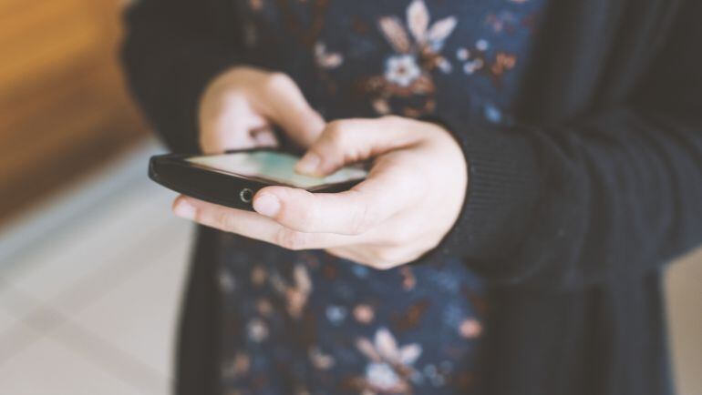 Una mujer usando el móvil