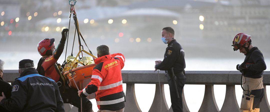 Un grupo de bomberos y la Policía Local rescata a un hombre en una zona de rocas en el paseo marítimo coruñés, a 13 de diciembre de 2021, en A Coruña, Galicia