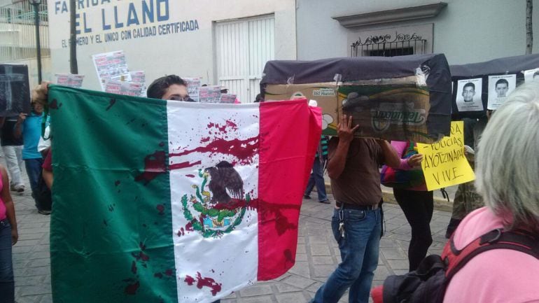 mexicanos protestan con una bandera teñida de sangre por la violencia inusitada que ha protagonizado la campaña electoral en este país, provocando la muerte de 130 personas, la mayoria candidatos y familiares 