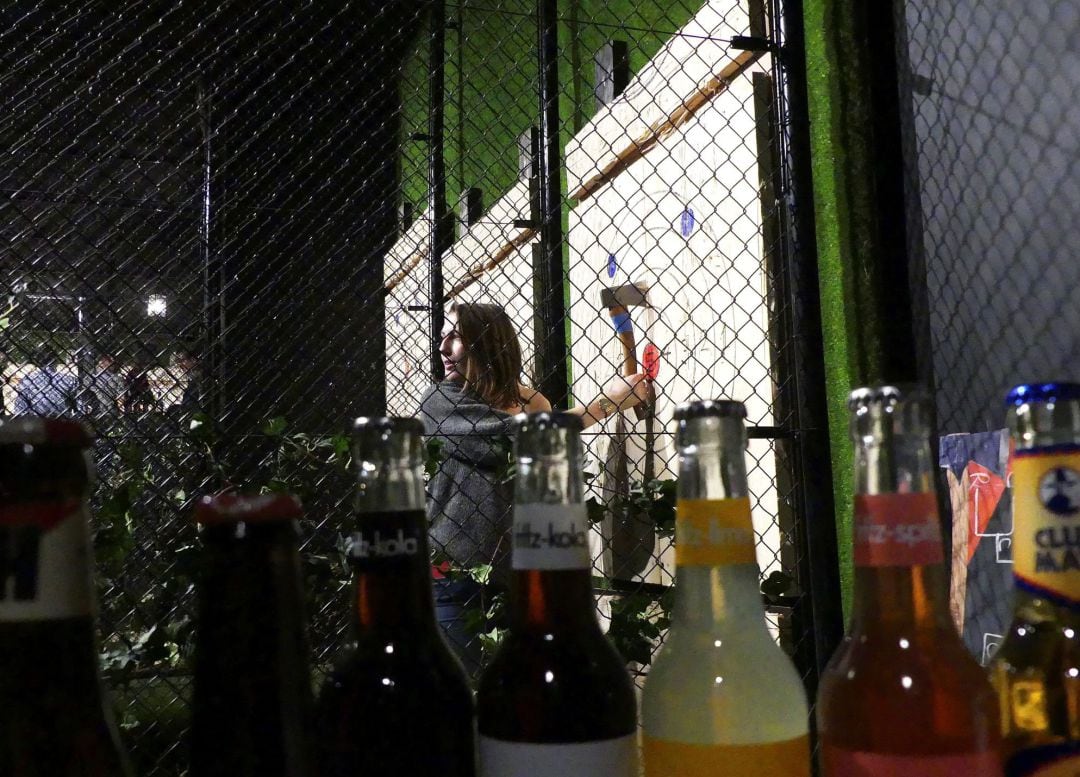 Una mujer recoge su hacha en el WoodCutter Urban Axe Throwing de Bruselas.