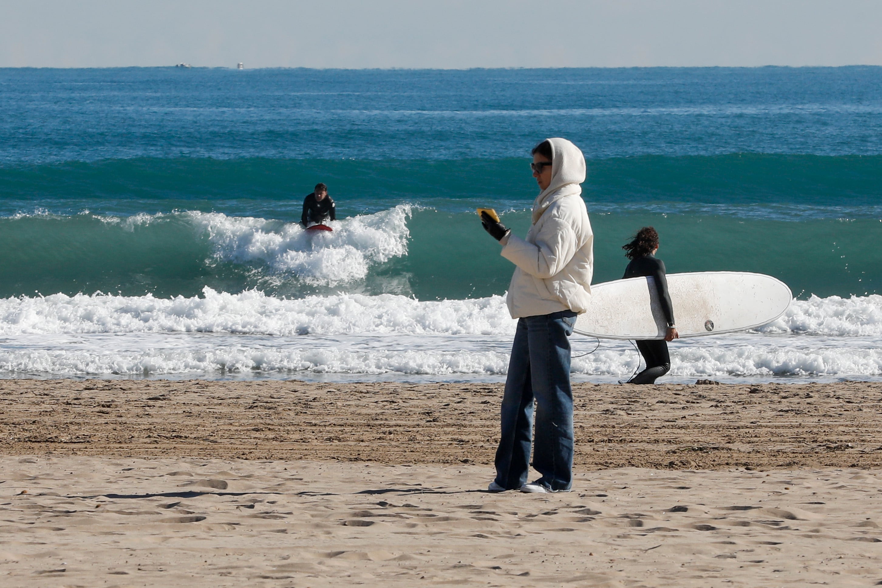 Unos surfistas en el agua en la Playa de la Malvarrosa de Valencia,