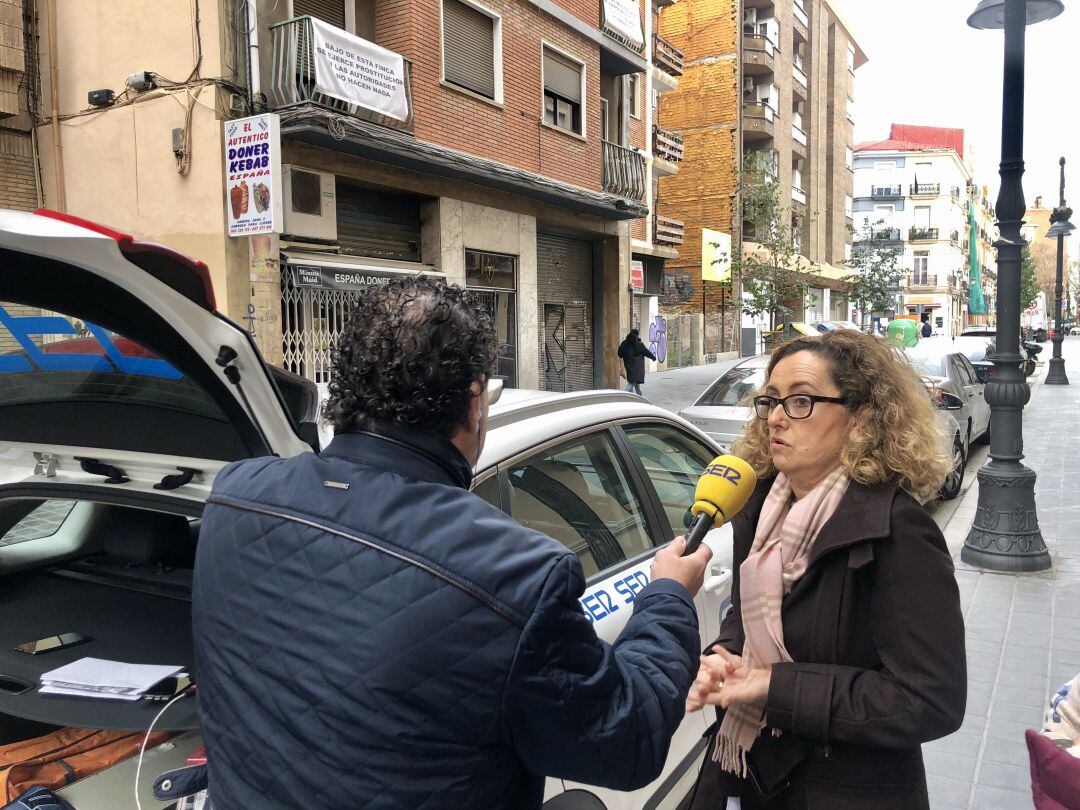 Entrevista a las vecinas que viven sobre el prostibulo de la calle San Pedro Pascual de València en el momento en que una mujer sale del local.