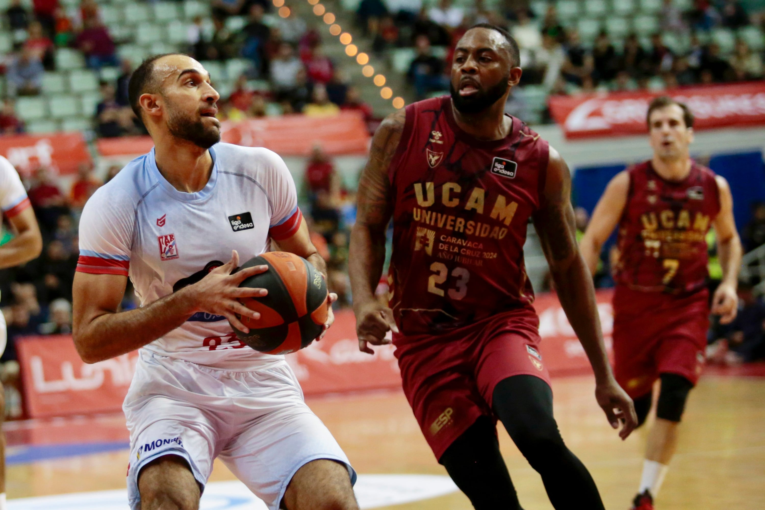 MURCIA, 27/11/2022.- El base del Monbus Obradoir Phil Scrubb con el balón ante la mirada de Anderson, del UCAM Murcia, durante el partido de la novena jornada de Liga Endesa que disputan en el Palacio de los Deportes de Murcia. EFE/Juan Carlos Caval
