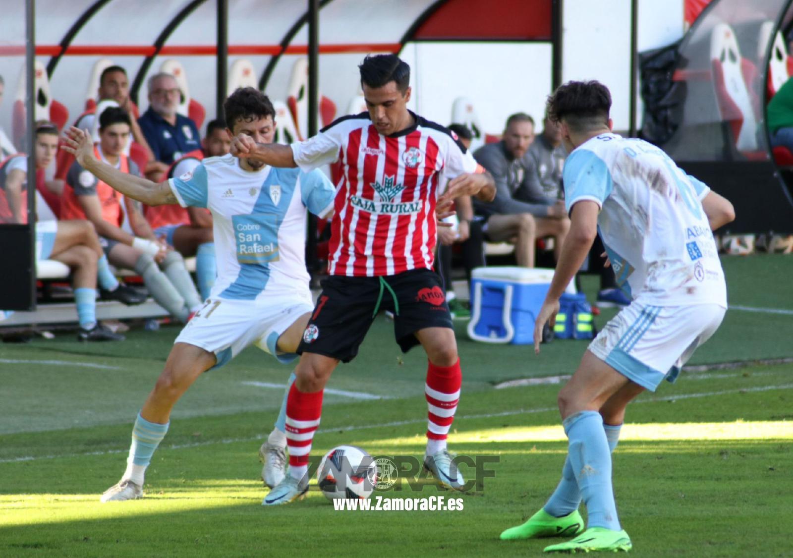 Dani Hernández protege la bola ante dos jugadores de la SD Compostela.