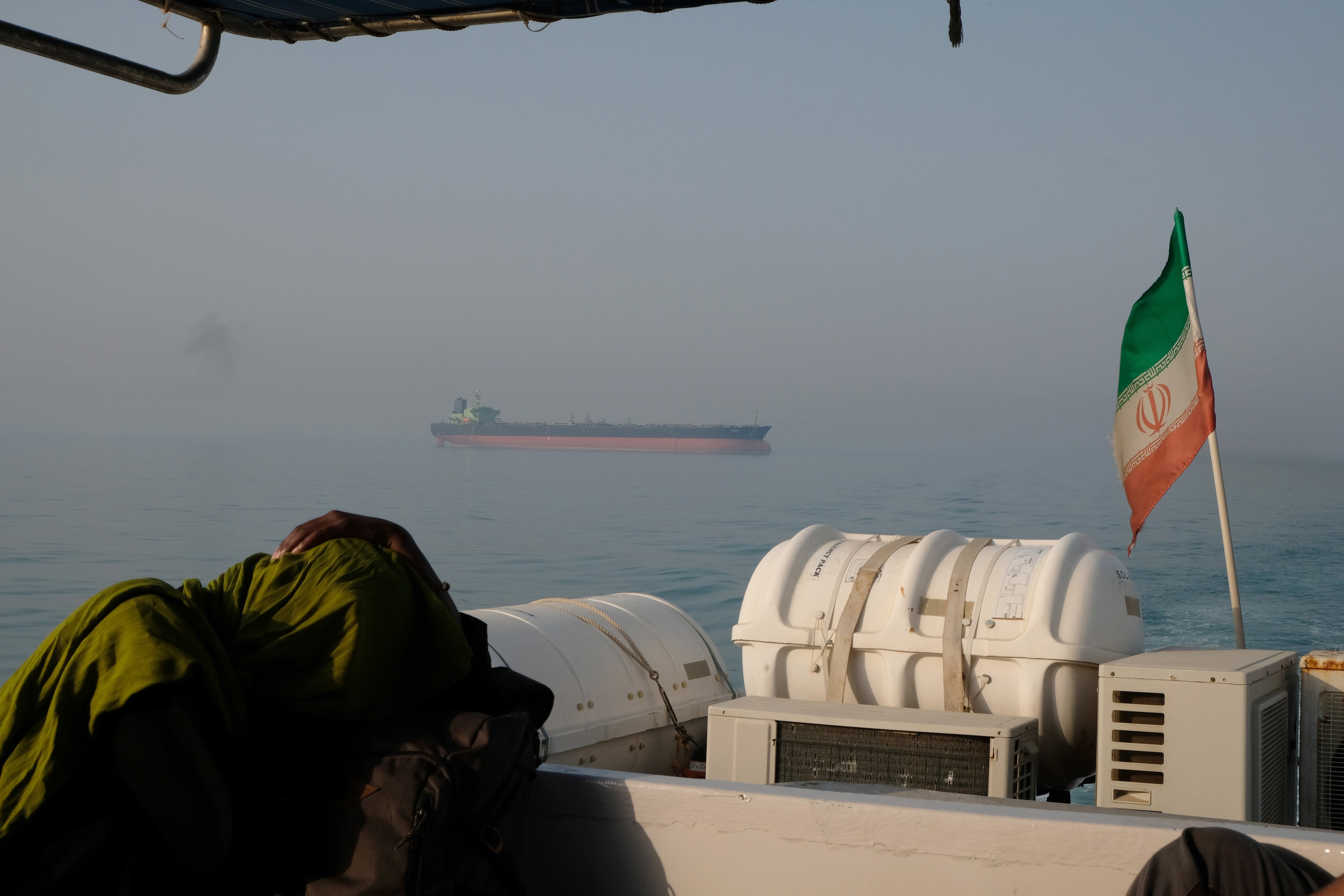 Un turista extranjero descansa en un barco de pasajeros con la bandera iraní ondeando en las aguas del estrecho de Ormuz el 2 de mayo de 2017, cerca de la isla de Ormuz, Irán. 