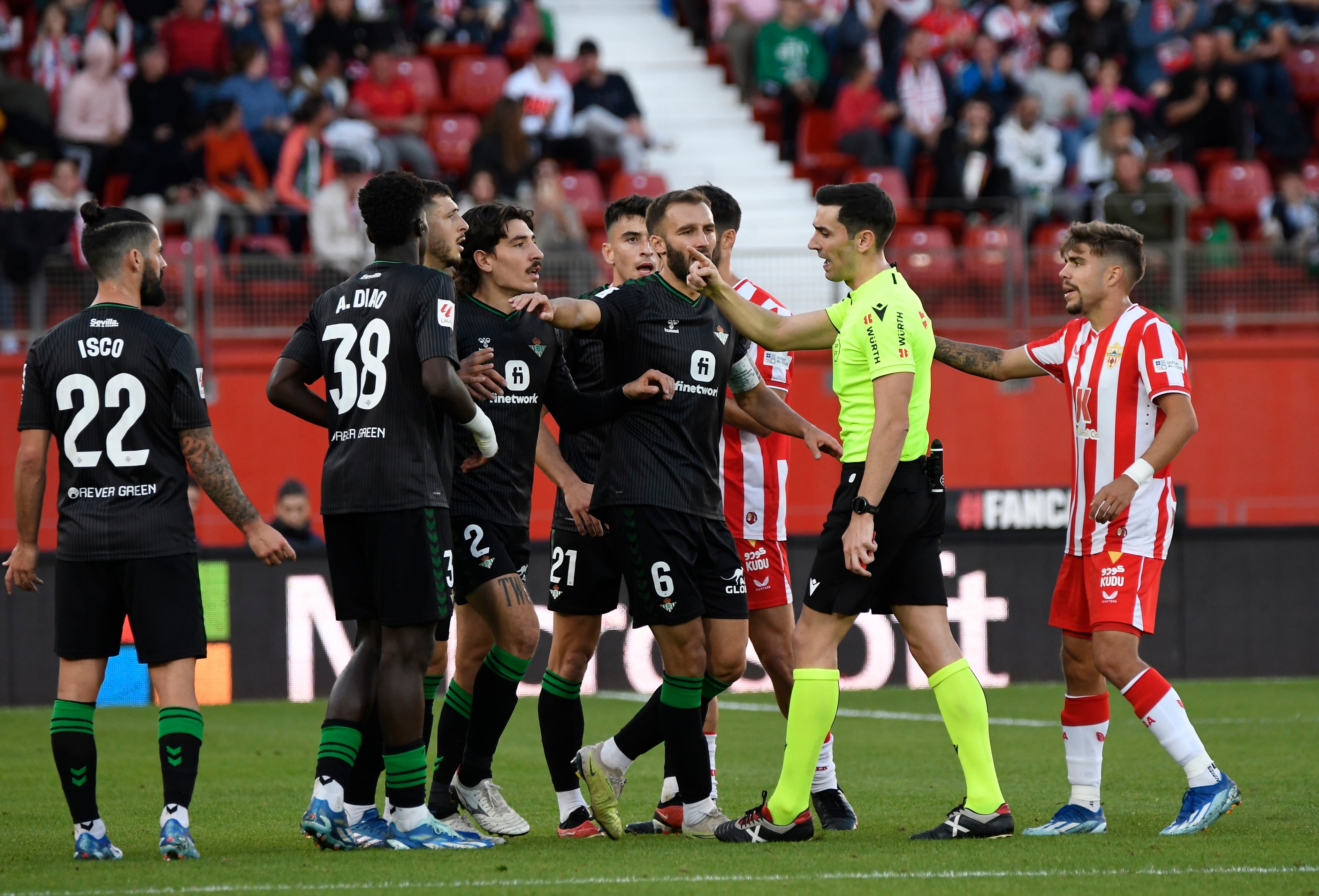 ALMERÍA, 03/12/2023.- El colegiado Muñiz Ruis (2d) expulsa al defensa del Real Betis Héctor Bellerín (4i) durante el encuentro correspondiente a la jornada 15 de LALiga EA Sports disputado entre la UD Almería y el Real Betis esta tarde en Power Horse Stadium de Almería. EFE / Carlos Barba